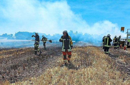 Feuerwehr und Helfer versuchen, die Flammen zu löschen und ihnen den Weg Richtung Wald nicht zu ermöglichen. Foto: Weisser