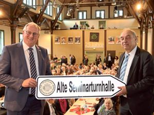 OB Jürgen Großmann (links) überreichte Wolfgang Schäfer ein Hinweisschild zum Jubiläum des Fördervereins Alte Seminarturnhalle. Foto: Priestersbach