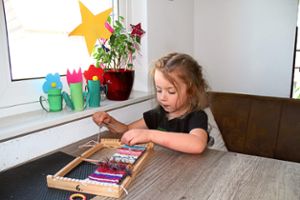 Das Kindergartenkind Lea arbeitet Zuhause fleißig an ihrem Webrahmen.Foto: Haug Foto: Schwarzwälder Bote