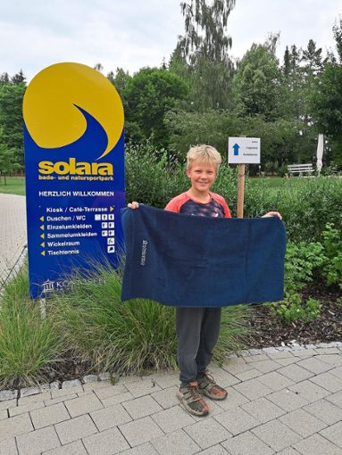 Lars Thomas freut sich über das Handtuch, das ihm die  Gemeinde Königsfeld bei seinem Freibad-Besuch überreicht. Foto: Gemeinde Foto: Schwarzwälder Bote