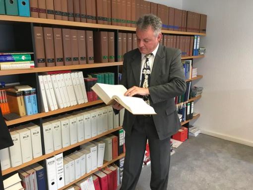 Joachim Bloch wälzt das Gesetzbuch. Er ist als Rechtsanwalt tätig. Foto: Wagner