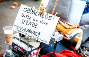 Ein Schild mit der Aufschrift Obdachlos – Bitte um eine Spende – Danke! steht neben den Habseligkeiten eines Obdachlosen, die auf einem Bürgersteig liegen. (Symbolfoto) Foto: Hauke-Christian Dittrich