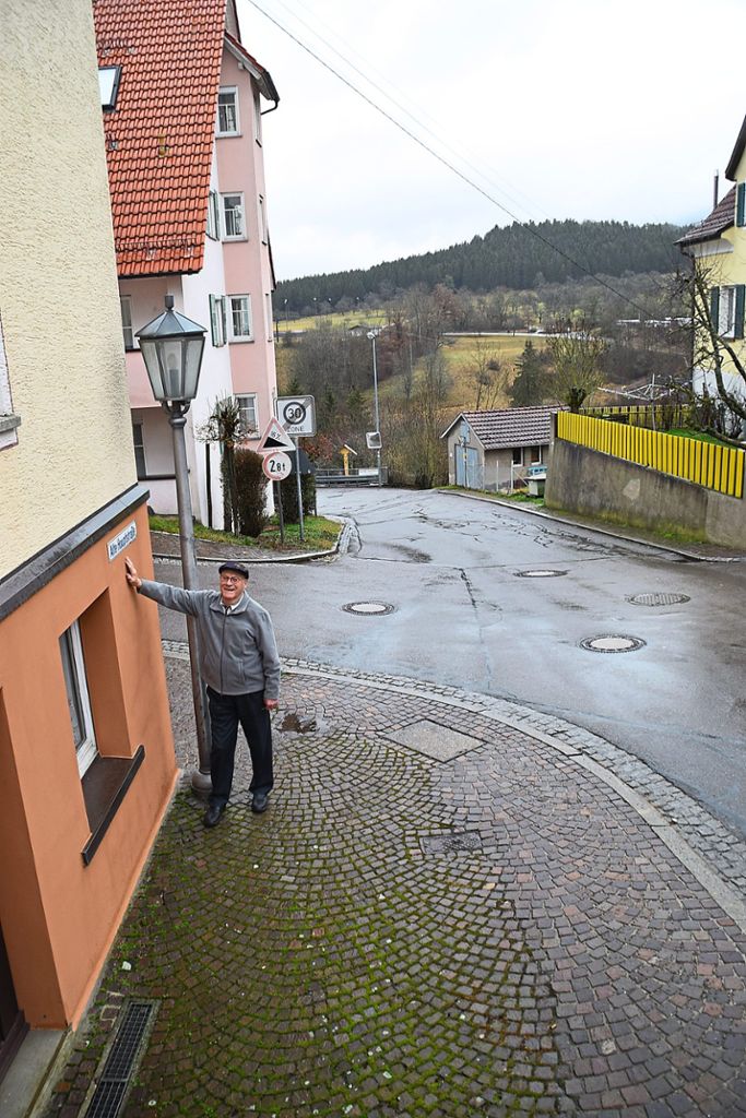 Berthold Schuß zeigt an seinem Wohnhaus das Straßenschild Alte Hauptstraße. Hier verlief die ehemalige Handelsstraße bergab in Richtung Palmbühl. Fotos: Visel