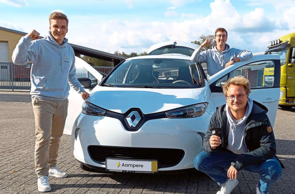 Niko Schmidt (von links), Florian Reister und Max Rost freuen sich über ihr erstes verkauftes E-Auto. Foto: Peter Dunst