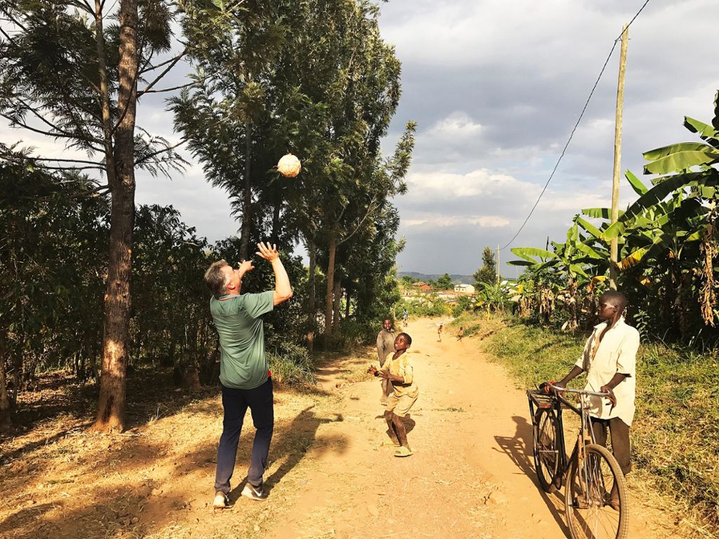 Michael Bitzer spielt mit einem Jungen, der aus einem Luftballon einen Ball gebastelt hat, Volleyball. Foto: Bitzer