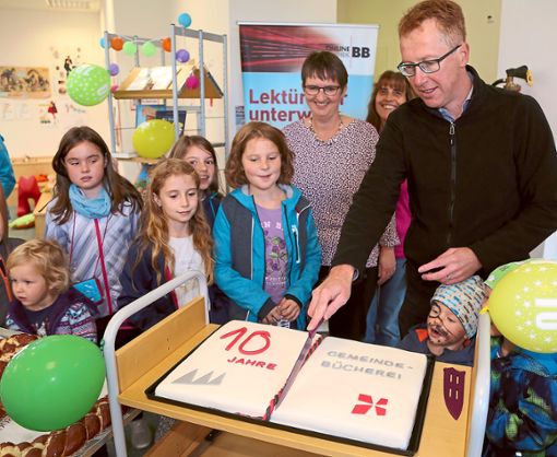 Bürgermeister Hans Michael Burkhardt schnitt die Geburtstagstorte in der Gemeindebücherei an. Foto: Priestersbach Foto: Schwarzwälder Bote