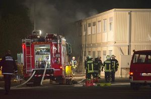 Feuerwehrleute vor der brennenden  Flüchtlingsunterkunft in Rottenburg am Neckar. Foto: dpa