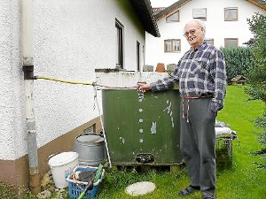 Willi Voss steht in seinem Hausgarten in Ratshausen, wo er in einem 1000-Liter-Fass Regenwasser sammelt. Bei der Berechnung der gesplitteten Abwassergebühr wird dieses Wasserfass aber nicht berücksichtigt. Das ärgert ihn. Foto: Visel