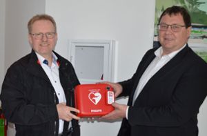 Bürgermeister Michael Lehrer (rechts) bedankt sich bei Teilmarktleiter Martin Guhl für die Spende eines Defibrillators. Foto: Herzog