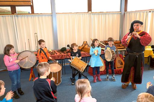 Die  Schüler der zweiten Klasse der Dom-Clemente-Schule betätigen sich an den verschiedenen Trommeln, während Thelonius Dilldapp eine Rauschflöte spielt. Foto: Schwarzwälder Bote