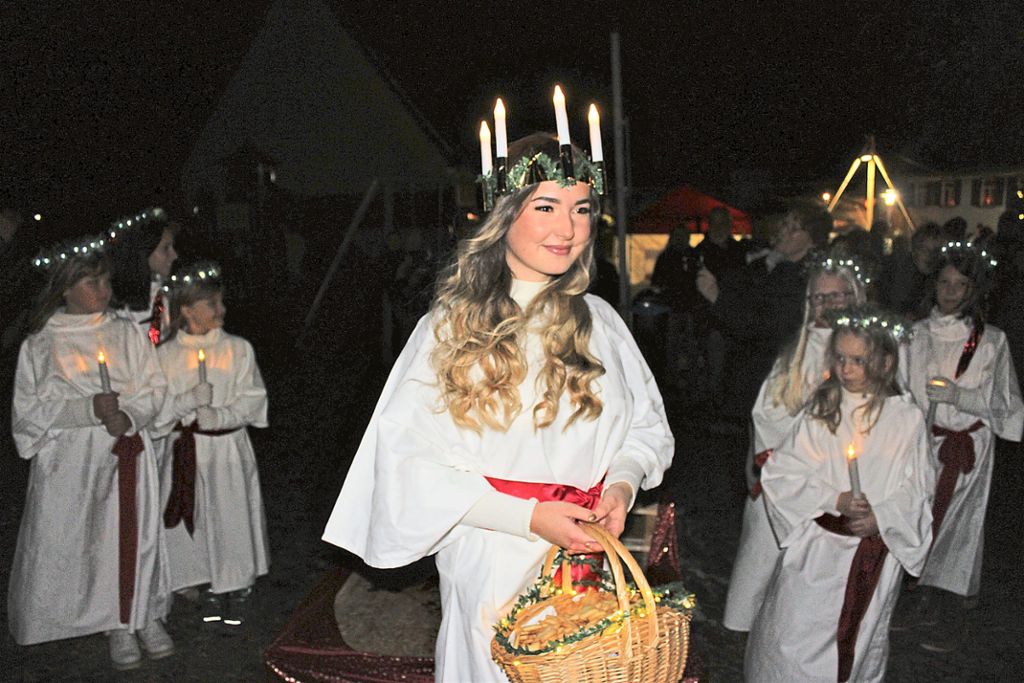 Höhepunkt des Lichterfests: Die Heilige Lucia, verkörpert durch Lena Stehle, zieht ein.   Foto: Breisinger