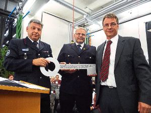 Christian Krause und Markus Heinzelmann nehmen den Schlüssel fürs neue Feuerwehrgerätehaus von Uwe Schlenker (von links) entgegen. Foto: Streck Foto: Schwarzwälder-Bote