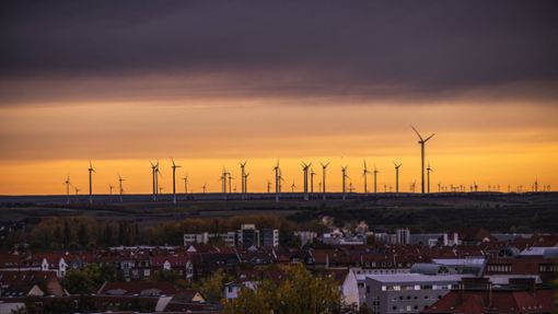 Windräder im Sonnenaufgang hinter Erfurt. Foto: IMAGO/Jacob Schröter