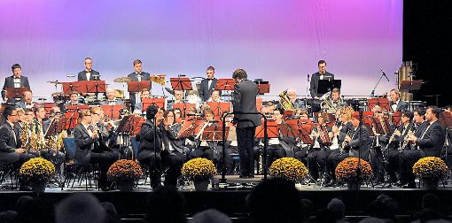 Die Stadtkapelle mit Dirigent Nicholas Reed auf der Stadthallenbühne, die passend zum Konzertanlass mit Chrysanthemen geschmückt war. Foto: Baublies