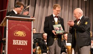 Peter Flaig und Matthias Krause (von links) überreichen dem verdienten Musiker einen Bildband. Foto: Kiolbassa Foto: Schwarzwälder Bote