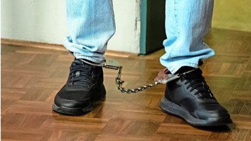 Mit Fußfesseln betreten die inhaftierten Angeklagten den Gerichtssaal des Landgerichts Konstanz. Foto: dpa/Silas Stein