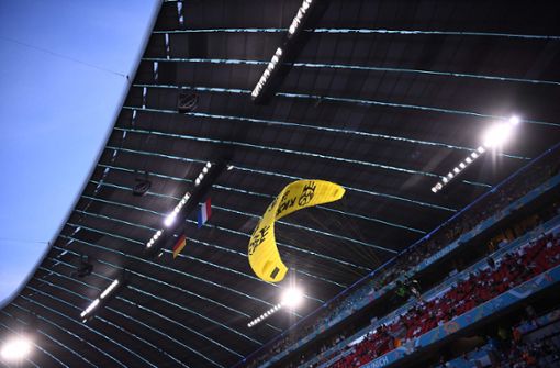 Der Greenpeace-Aktivist segelte vor dem Anpfiff ins Stadion. Foto: AFP/FRANCK FIFE