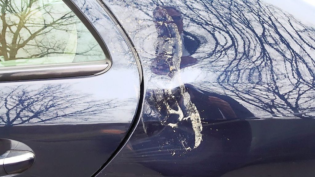 Das Konterfei des AfD-Kreisvorsitzenden aus der Region, Joachim Senger, spiegelt sich im Lack, als er den Schaden an seinem Auto fotografiert. Foto: Senger