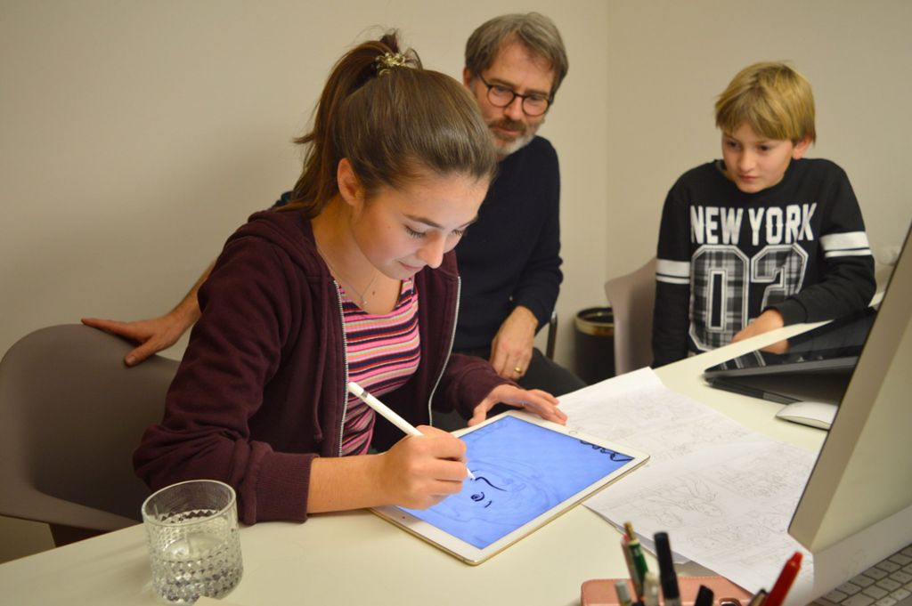 Der Illustrator Michael Meier zeigt Mara Haueisen und Nathan Hilser, wie aus einer Bleistiftzeichnung ein gedruckter Comic wird.   Foto: Cools