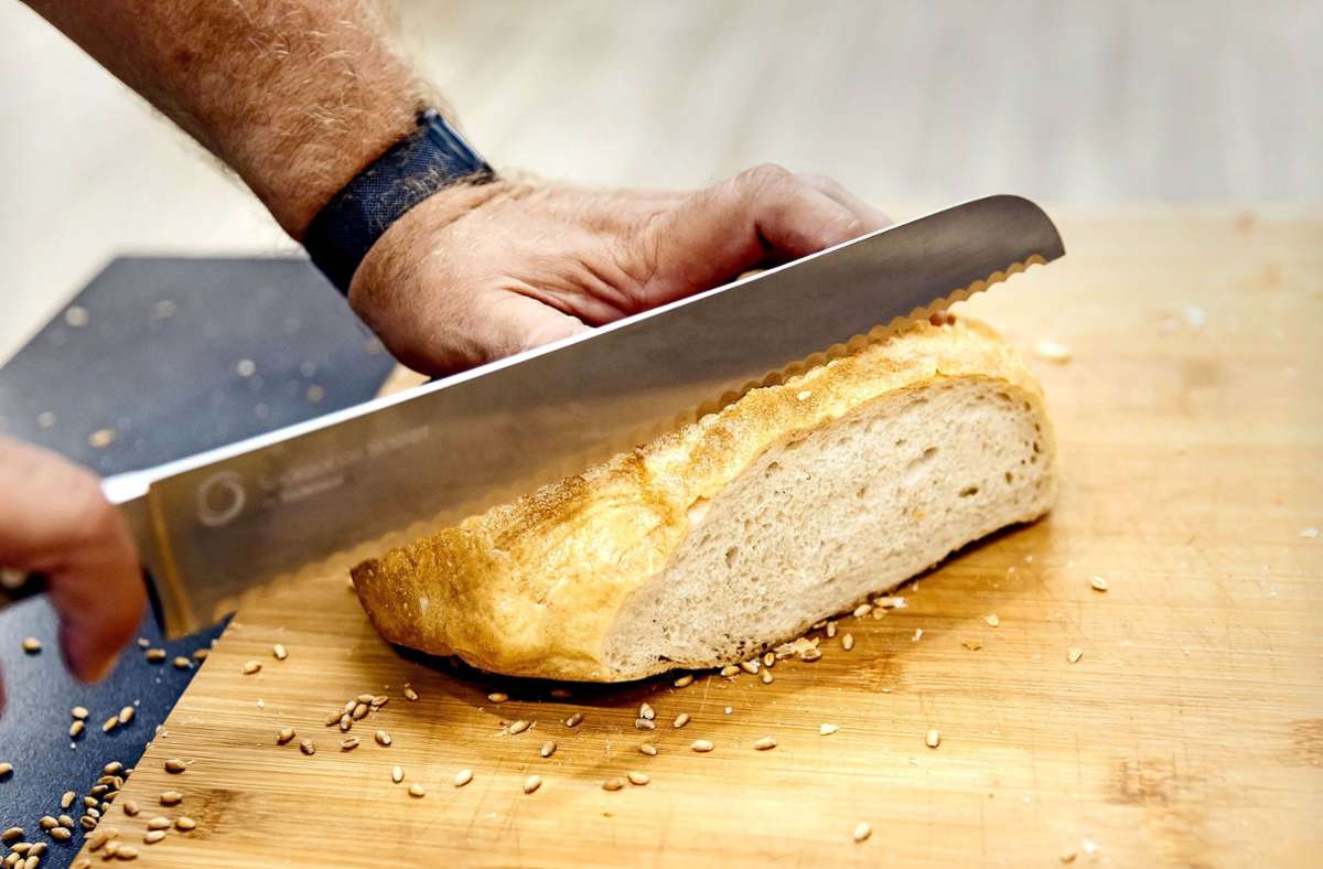 Bäcker Heiner Beck schneidet ein Brot aus Futtergetreide auf. Foto: © Verena Müller / Greenpeace/Verena Müller