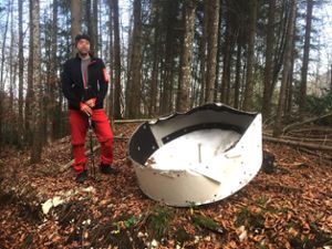 Nicht nur dieser Wanderer wundert sich: Direkt unterhalb des Plettenbergturms liegt eine verbeulte Parabolantenne im Roßwanger Wald. Foto: Wagner