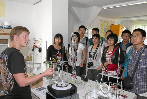 Luca Zipfel (links) erklärt den chinesischen Schülern seine Idee, Energie chemisch zu speichern. Foto: Priestersbach Foto: Schwarzwälder-Bote