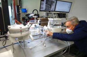 Faszination Medizintechnik. Thomas Bogenschütz zeigt auf die Herzklappenprothese, die in diesem Laborapparat zu Testzwecken im Dauerbetrieb pulsiert. Foto: Stopper