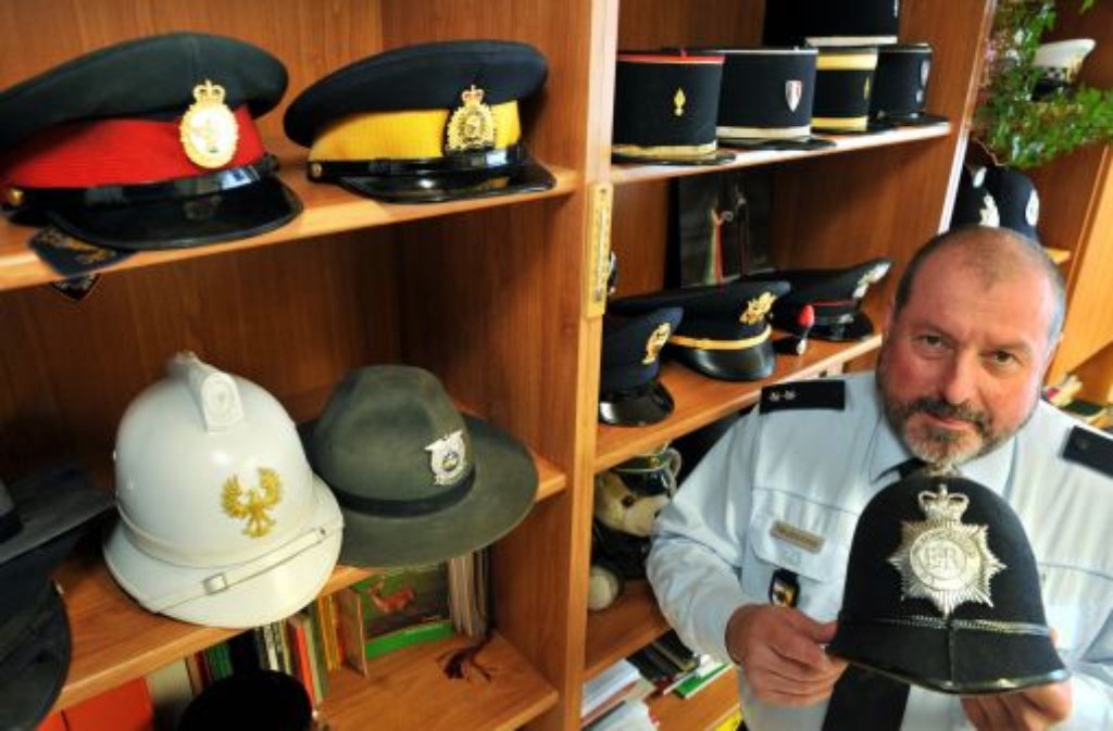 Polizeioberkommissar Rainer Neubronner zeigt seine Sammlung historischer und aktueller Polizeimützen aus aller Welt.
