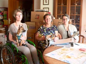 Sie hoffen, doch noch bis 30. September eine neue Wohnung zu bekommen: Sandra (von links), Patricia und Sarah Gruel mit den kleinen Hunden Jimmy, Lucy und Shila. In dem Aktenordner auf dem Tisch sind die Bemühungen der drei Frauen dokumentiert, eine neue Bleibe zu finden. Foto: Krokauer