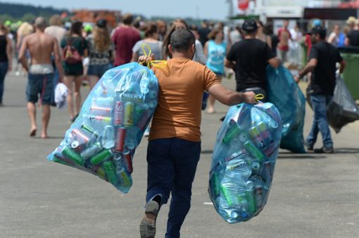Ein Mann trägt beim Southside Festival auf dem Zeltplatz zwei Müllsäcke mit Bierdosen zur Sammelstelle. Am 21.06.2019 beginnt das diesjährige Festival. Die Veranstalter hoffen auf möglichst wenig Müll.  Foto: dpa