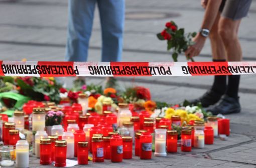 Blumen werden in Würzburg vor einem abgesperrten Kaufhaus, dem Ort des Anschlags, niedergelegt. Foto: dpa/Karl-Josef Hildenbrand