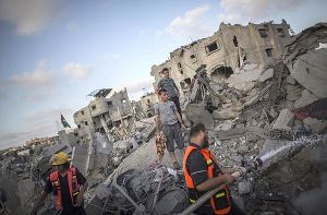 Palästinenser nutzen die Feuerpause in Gaza-Stadt, um nach Verwertbarem in ihren zerstörten Häusern zu suchen. Foto: dpa