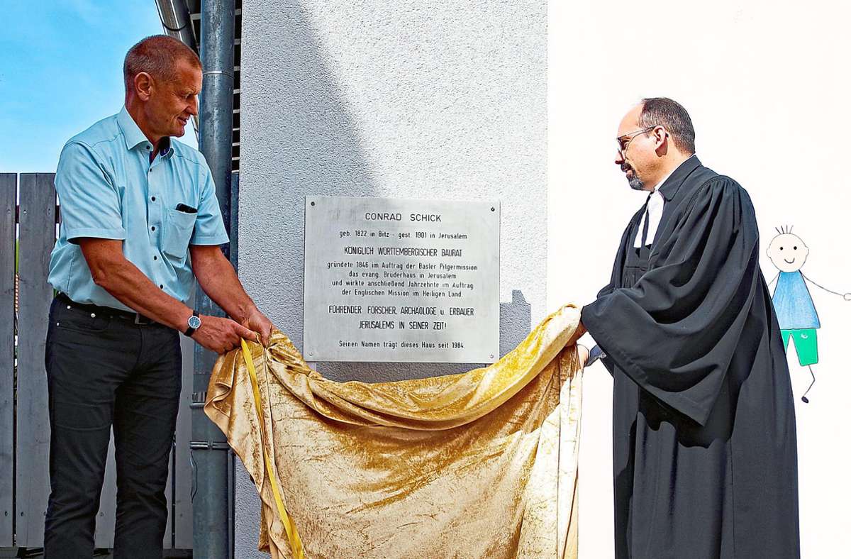 Bürgermeister Hubert Schiele (links) und Pfarrer Thomas Gerold enthüllen die Gedenktafel an Conrad Schick.