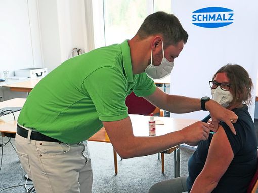 Schmalz-Betriebsarzt Andreas Kreidler  erteilt der Mitarbeiterin Alexandra Würth die erste betriebliche Impfung gegen Corona. Foto: J. Schmalz GmbH
