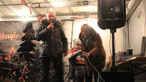 Mit Hilfe der vierjährigen Juna schalten Hans-Peter Fauser und Gislinde Sachsenmaier die Weihnachtsbeleuchtung ein. Foto: Steinmetz