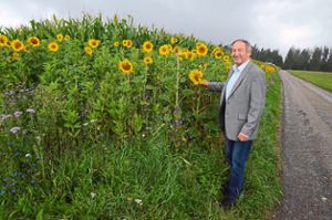 Willi Armbruster steht an einem Blühstreifen, den er  an einem  seiner Maisfelder gepflanzt hat. Foto: Schwark
