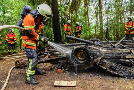 Feuerwehrkräfte löschen den total niedergebrannten Wohnwagen. Foto: KFV Calw / Udo Zink
