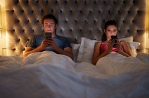 Gemeinsam einsam. Abends im Bett starrt jeder auf sein Smartphone. Foto: imago images/Shotshop/Monkey Business 2 via www.imago-images.de