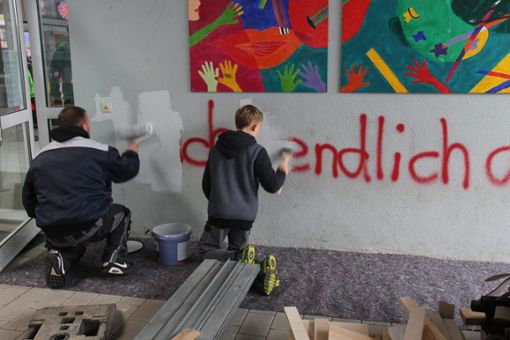 Mit Pinseln und Schwämmen rücken viele Helfer den Schmierereien auf der Villingendorfer Schule zu Leibe. Foto: Schmidt