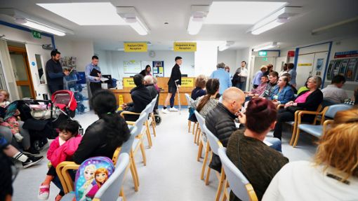 Normale Bürger im vollen Warteraum einer NHS-Klinik in Milton Keynes Foto: picture alliance / /Hannah McKay