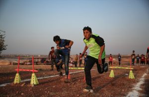 Wie bei den Olympischen Spielen trugen die Kinder die Farben ihres Lagers. Foto: dpa/Anas Alkharboutli