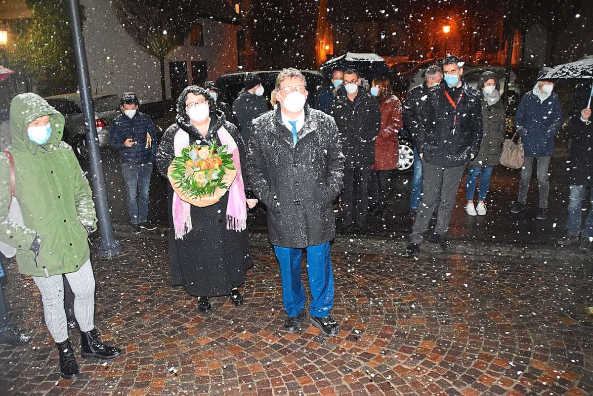 Wahlsieger Karl-Josef Sprenger und seine Frau Nadja  stehen im Schneegestöber vor dem Rathaus und freuen sich über das Ergebnis, das Kerstin Kipp verkündet. Foto: Visel