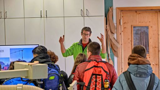 Sebastian Eberhardt ist Chef von Holzbau Fassnacht. Er erklärt den Schülern der Realschule, was man in seinem Betrieb alles mit anpacken und aufbauen kann. Foto: Juergen Lueck