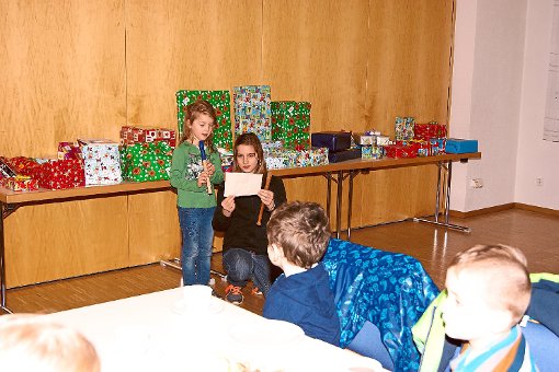 Zwei Mädchen flöten  Weihnachtslieder. Im Hintergrund sind die Geschenke. Foto: Vögele Foto: Schwarzwälder-Bote