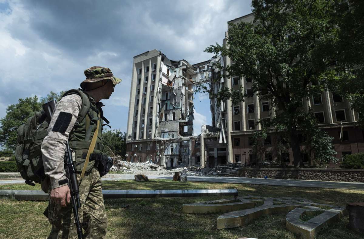 Ein Ukrainischer Soldat vor einem zerstörten Verwaltungsgebäude (Archivbild) Foto: dpa/Evgeniy Maloletka