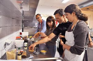 Sven Götz (Zweiter von rechts) zeigt Thorsten Beck  und zwei Schülerinnen, wie die Patties für die Tofu-Burger geformt werden. Foto: Reinhard