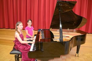 Auch dem achtjährigen Flüchtlingsmädchen Tekla (rechts) aus Ottenbronn hat Claudias mitreißende Musik sehr gefallen. Voller Hochachtung bestaunt sie die junge Pianistin und den ­großen Flügel.  Foto: Bausch Foto: Schwarzwälder Bote
