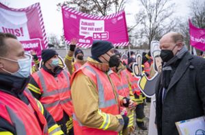 Reinhold Hilbers (CDU, rechts), Finanzminister von Niedersachsen und Verhandlungsführer auf der Arbeitgeberseite, geht am Verhandlungsort an einer Demonstration der Gewerkschaften vorbei. Foto: dpa/Christophe Gateau