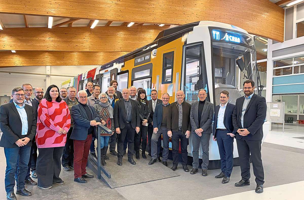 Vertreter der Verbandsversammlung Regionalstadtbahn Neckar-Alb stehtn vor einem Modell der neuen Züge. Foto: Hönes/Zweckverband Regional-Stadtbahn Neckar-Alb