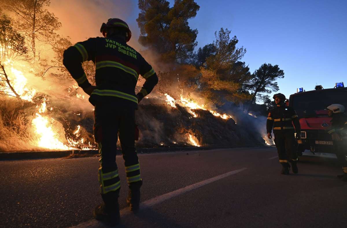 Feuerwehrleute beobachten einen Waldbrand in der Nähe von Zaton. Angeheizt durch starke Winde wüteten die Brände an der kroatischen Adria. Foto: Uncredited/AP/dp/a